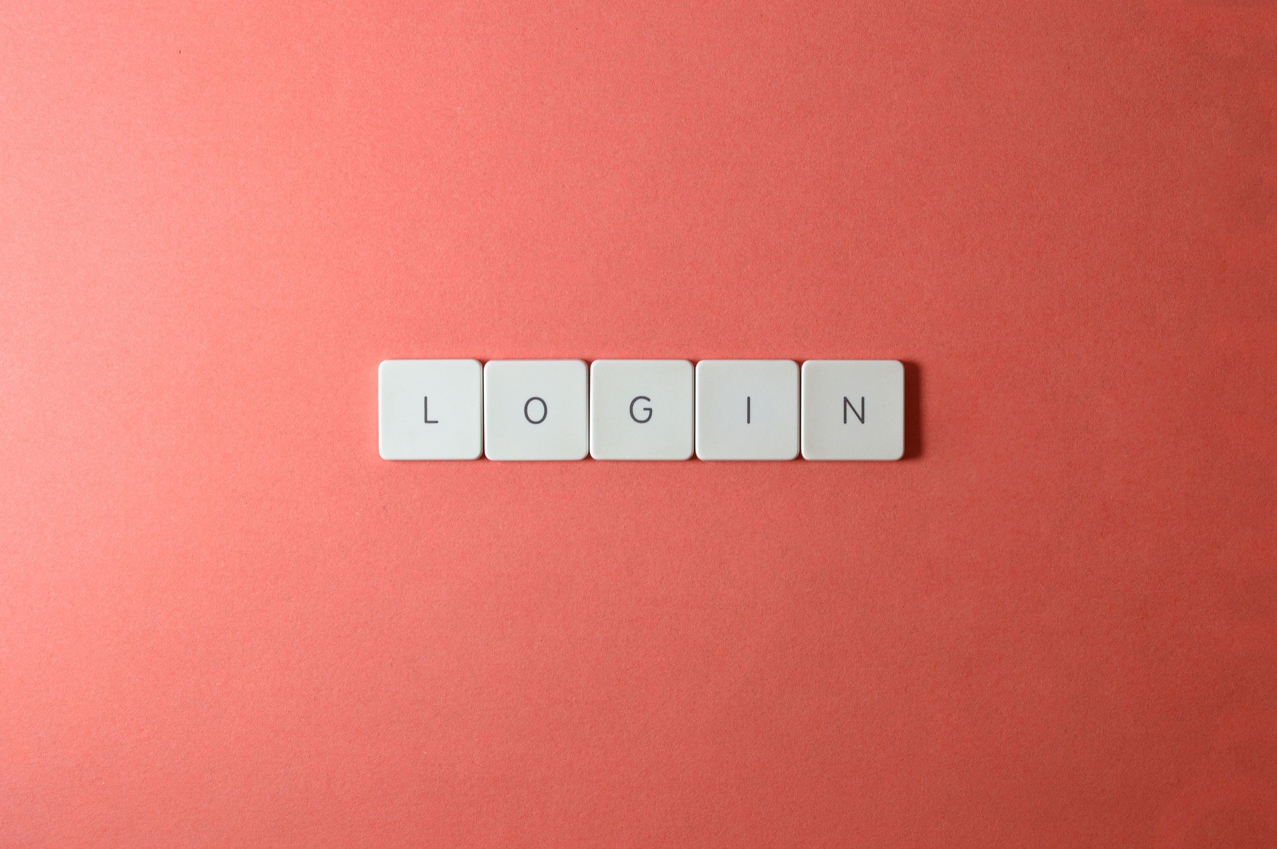 Close-up of login keyboard tiles on a coral background, perfect for tech themes.